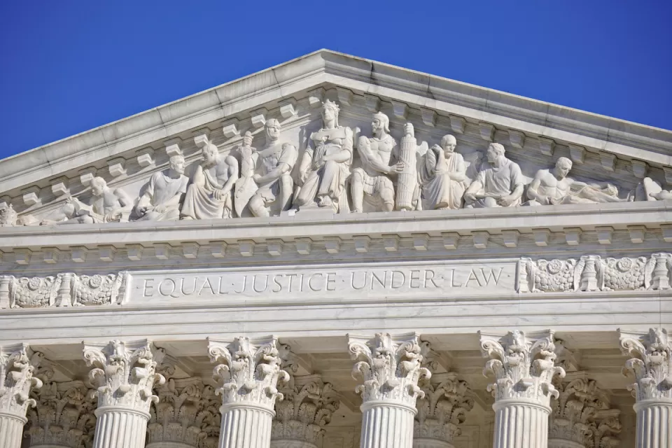 Close-up of U.S. Supreme Court building with "Equial Justice Under the Law" carving across top.